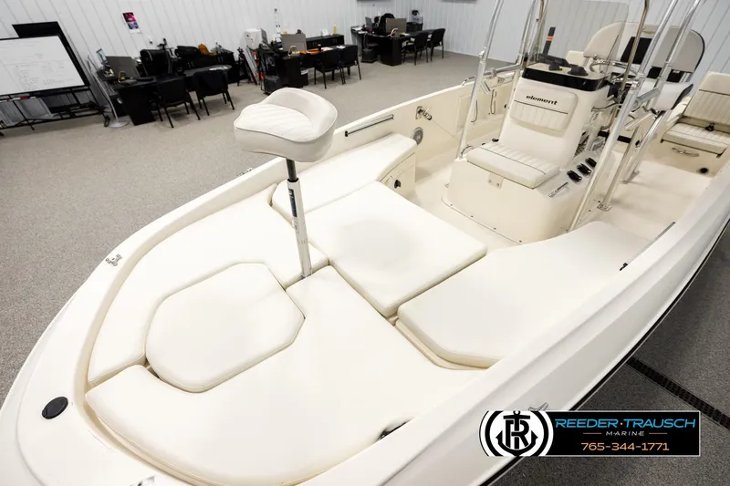 Slide: The Image of 2017 Bayliner Element F21 boat interior with white seating, displayed in a showroom. - 8