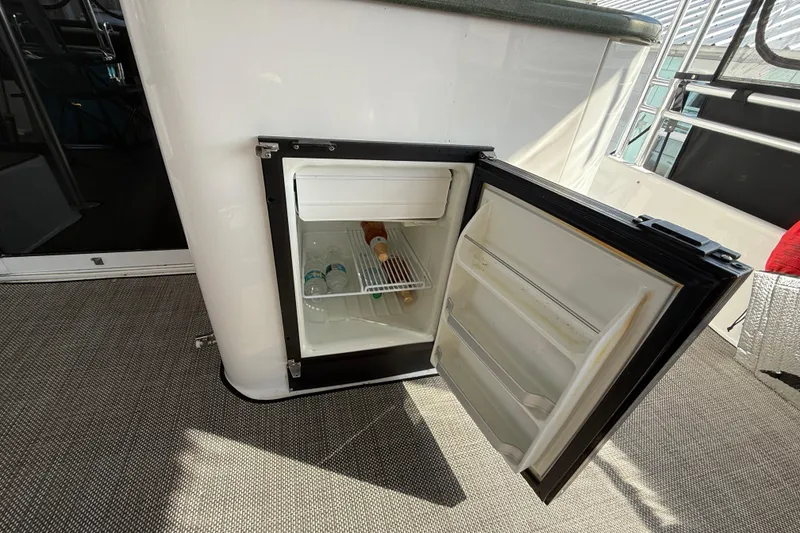Slide: The Image of Open mini fridge on 1998 Mainship 47 Motor Yacht, containing water bottles and a wine bottle. - 22
