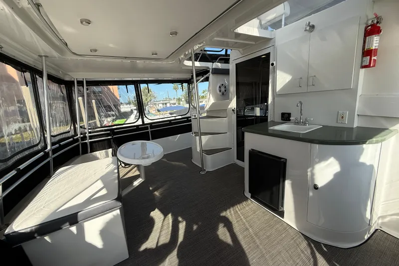 Slide: The Image of 1998 Mainship 47 Motor Yacht interior with seating, table, and kitchenette. - 26