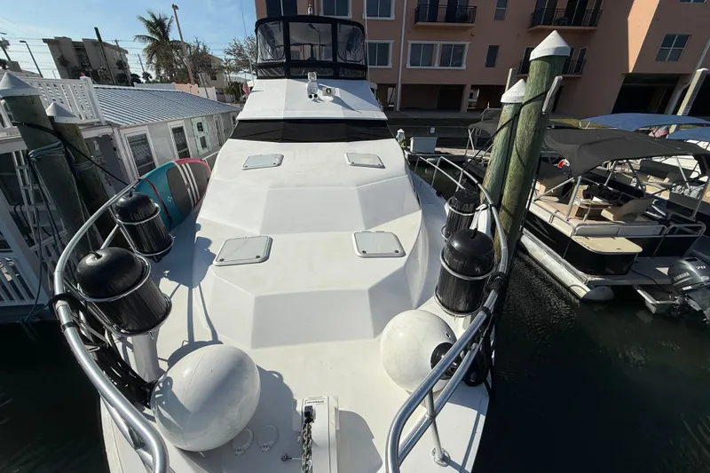 Slide: The Image of 1998 Mainship 47 Motor Yacht docked at marina, surrounded by other boats. - 4