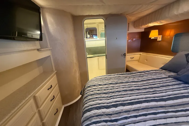Slide: The Image of Interior of 1998 Mainship 47 Motor Yacht bedroom with bed, TV, and storage. - 50