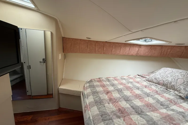 Slide: The Image of 1998 Mainship 47 Motor Yacht bedroom with bed, mirror, and skylight. - 59