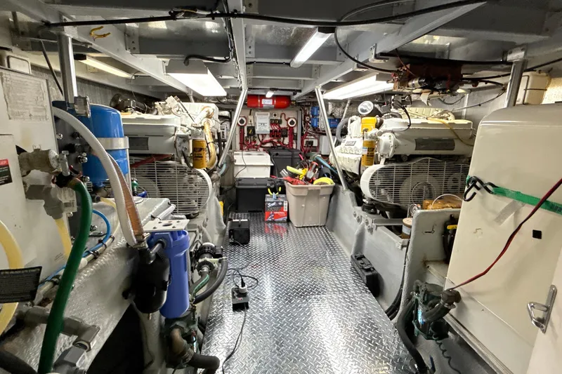 Slide: The Image of Engine room of a 1998 Mainship 47 Motor Yacht, featuring equipment and tools. - 73