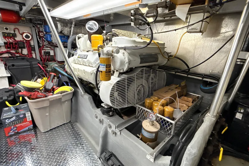 Slide: The Image of Engine room of a 1998 Mainship 47 Motor Yacht with tools and maintenance supplies. - 74