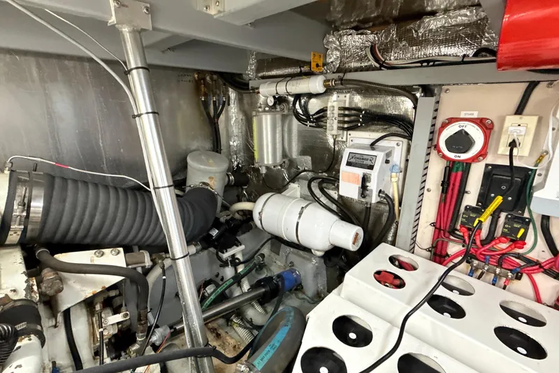 Slide: The Image of Engine room of a 1998 Mainship 47 Motor Yacht, showcasing mechanical components and wiring. - 77