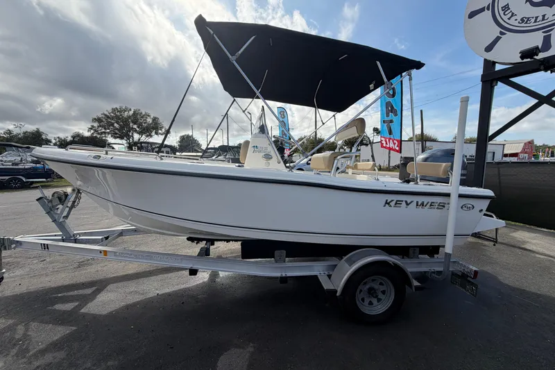 Slide: The Image of 2020 Key West 176 Sportsman CC boat on trailer, displayed outdoors under cloudy sky. - 7
