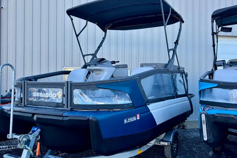 The Image of 2024 Sea-Doo Switch Sport 18 pontoon boat with canopy, parked on a trailer. - 0