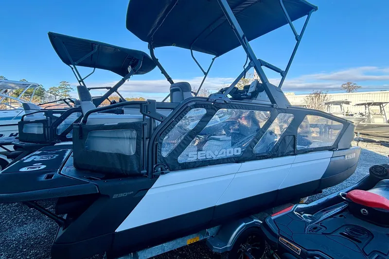 Slide: The Image of 2024 Sea-Doo Switch Sport 18 pontoon boat with canopy, parked outdoors. - 1