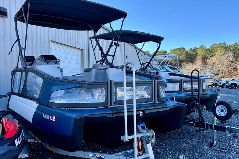 Slide: The Image of 2024 Sea-Doo Switch Sport 18 pontoon boats parked outdoors near a building. - 12