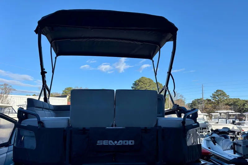 Slide: The Image of 2024 Sea-Doo Switch Sport 18 pontoon boat with canopy, parked outdoors. - 3