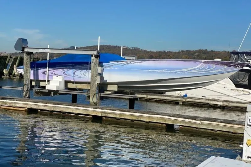 Slide: The Image of 2001 Nor-Tech 38 Super Vee boat docked on a lift at a marina. - 2