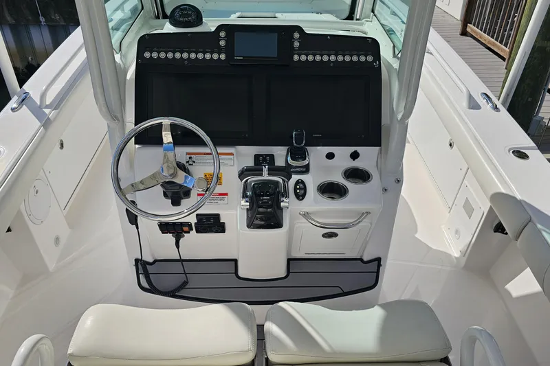 Slide: The Image of 2021 Everglades 273 Center Console boat helm with steering wheel and control panel. - 10