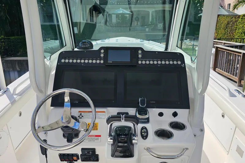 Slide: The Image of 2021 Everglades 273 Center Console boat dashboard with steering wheel and navigation controls. - 13