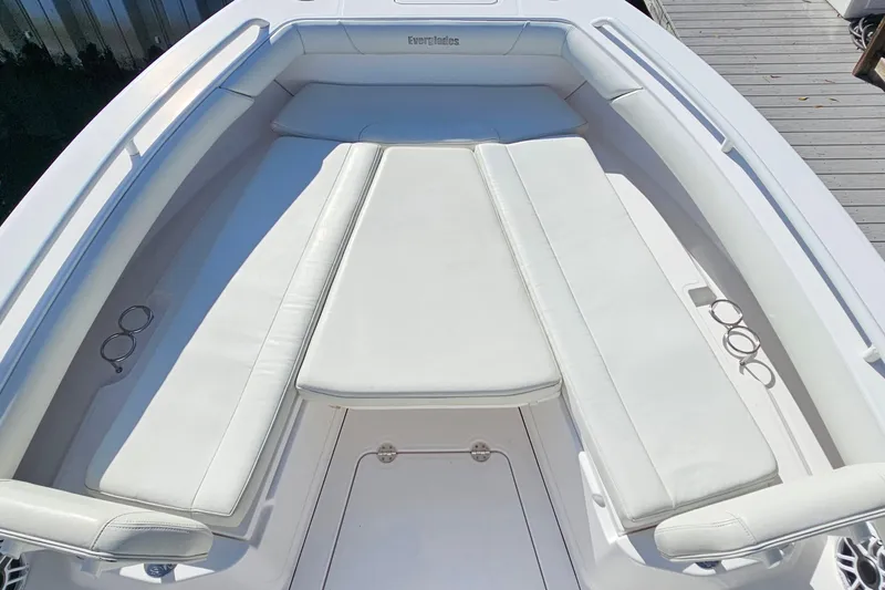 Slide: The Image of 2021 Everglades 273 Center Console boat with white cushioned seating and cup holders. - 31