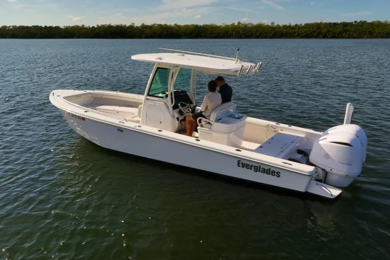 Slide: The Image of 2021 Everglades 273 Center Console boat on calm water, featuring sleek design and powerful engine. - 7