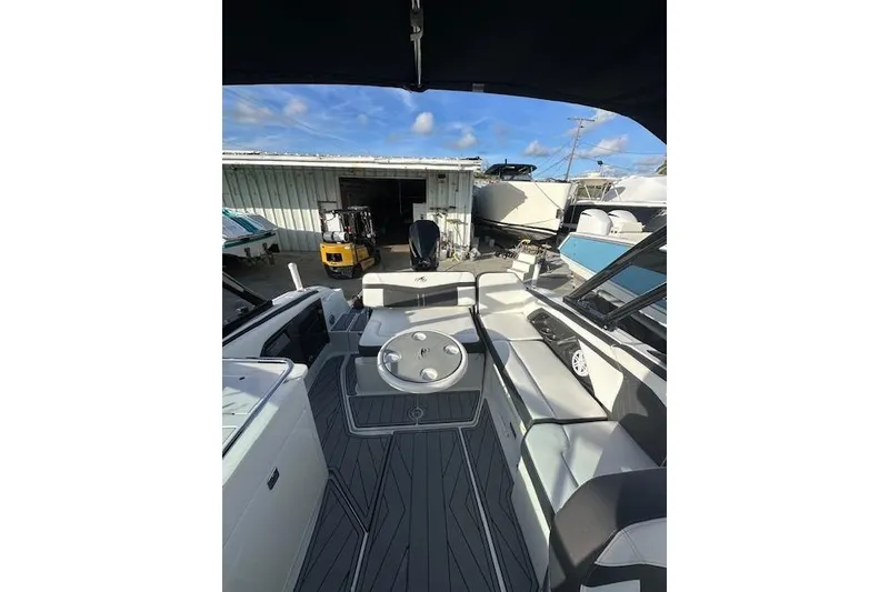 Slide: The Image of 2022 Monterey 255SS Super Sport boat interior with seating and table, docked outdoors. - 14