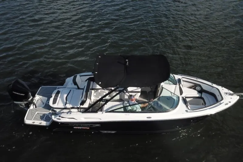 Slide: The Image of 2022 Monterey 255SS Super Sport boat on water, black canopy, sleek design. - 8