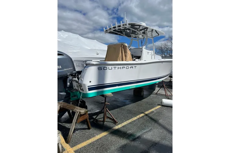 Slide: The Image of 2016 Southport 272 FE boat on stands, with Yamaha outboard, under cloudy sky. - 1