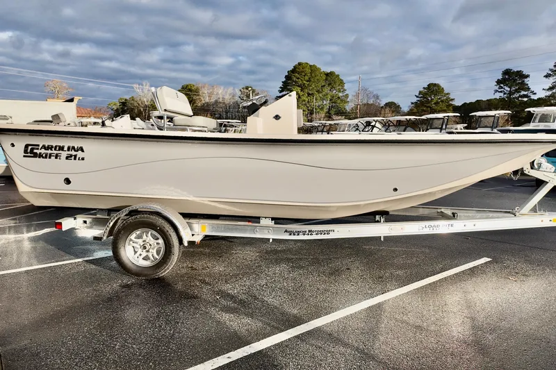 Slide: The Image of 2026 Carolina Skiff 21 LS boat on trailer in parking lot, under cloudy sky. - 8