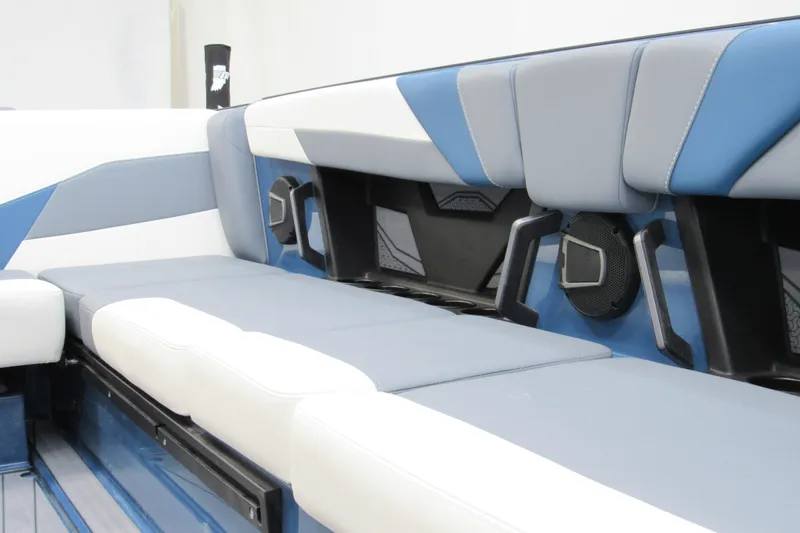 Slide: The Image of 2026 Axis T250 boat interior with blue and white cushioned seating and built-in speakers. - 13