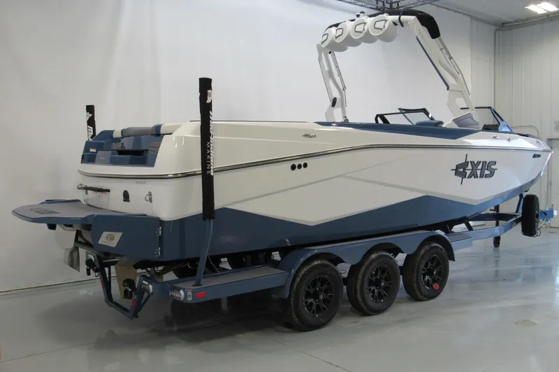 Slide: The Image of 2026 Axis T250 boat on trailer in indoor showroom setting. - 2