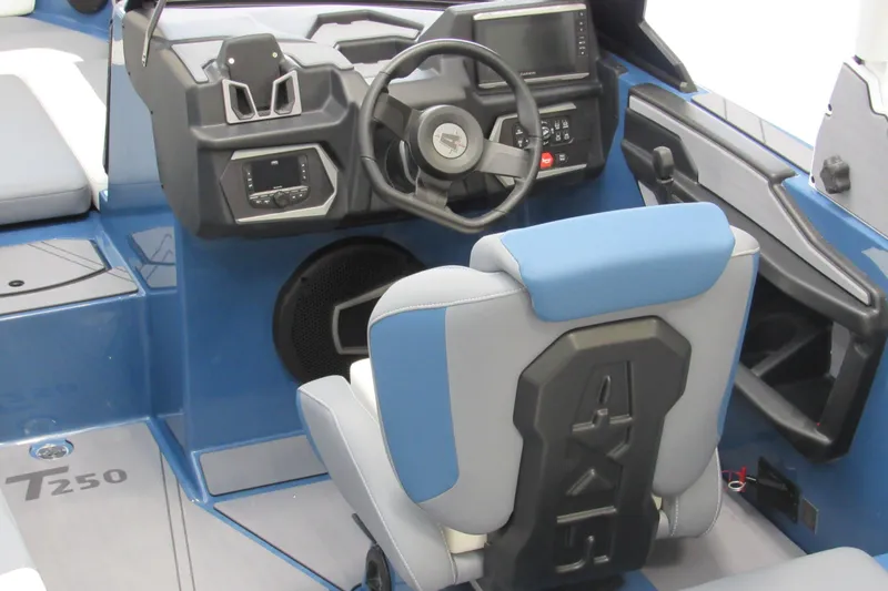 Slide: The Image of 2026 Axis T250 boat interior with steering wheel, dashboard, and blue-gray seating. - 3