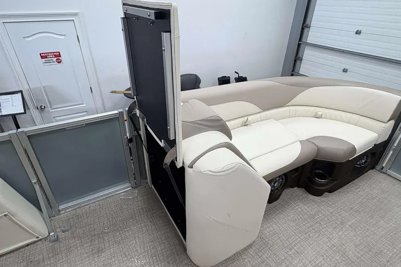 Slide: The Image of 2026 Avalon 2385 LSZ pontoon boat interior with beige seating in a showroom. - 20