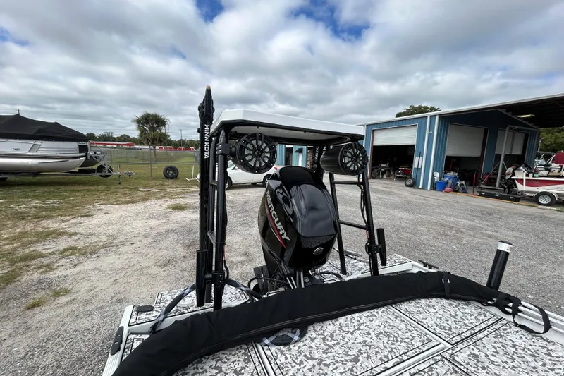 Slide: The Image of 2023 Crestliner 1600 Storm boat with Mercury engine, parked outdoors near a workshop. - 15