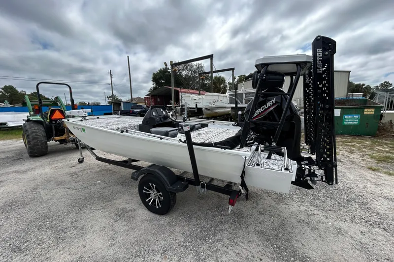 Slide: The Image of 2023 Crestliner 1600 Storm boat on trailer, featuring Mercury engine, parked outdoors. - 2