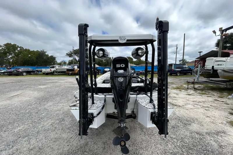 Slide: The Image of 2023 Crestliner 1600 Storm boat with powerful outboard motor, parked outdoors under cloudy sky. - 4