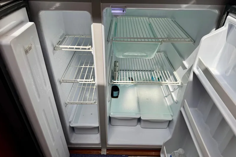 Slide: The Image of Empty Regal 4080 refrigerator interior, 2009 model, with open doors and visible shelves. - 21