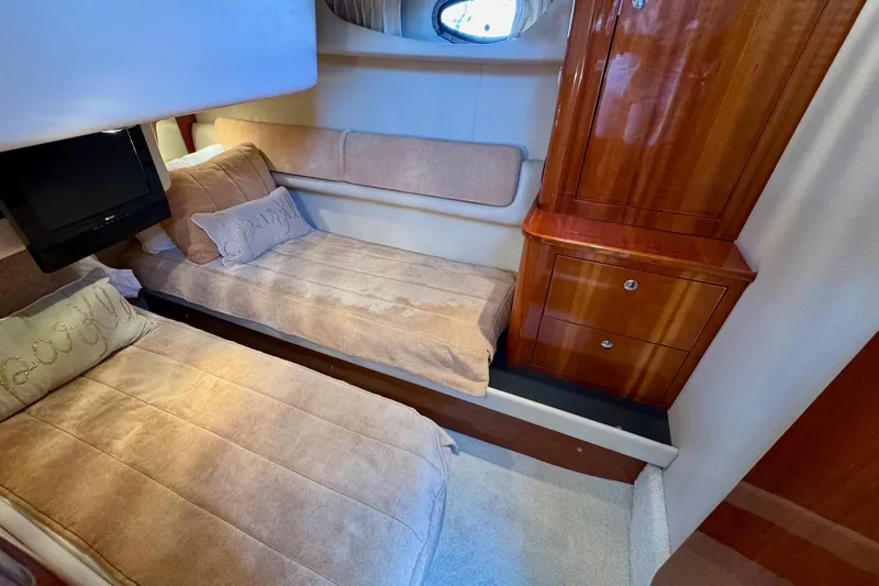 Slide: The Image of Luxurious 2009 Regal 4080 yacht cabin with twin beds and wooden cabinetry. - 24