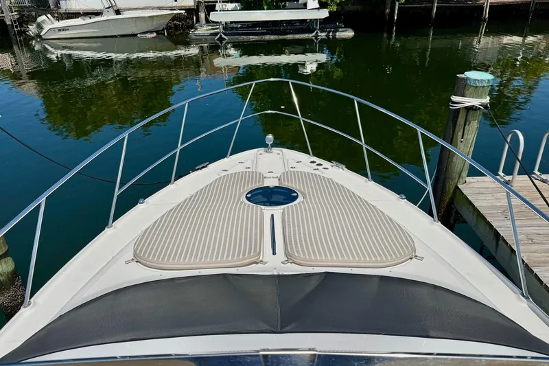 Slide: The Image of Bow view of a 2009 Regal 4080 yacht docked by the water. - 6