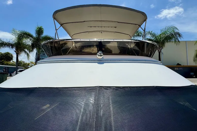 Slide: The Image of 2009 Regal 4080 yacht with canopy, docked near palm trees under blue sky. - 7