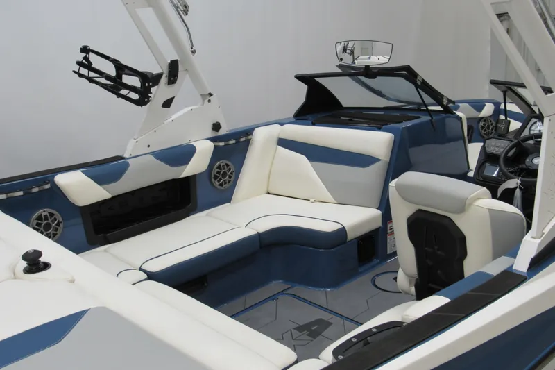 Slide: The Image of 2021 Axis A20 boat interior with blue and white seating, modern dashboard, and speakers. - 5