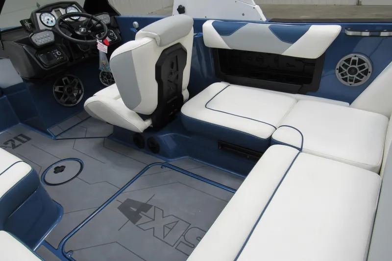 Slide: The Image of 2021 Axis A20 boat interior with white and blue seating, modern dashboard, and speakers. - 6