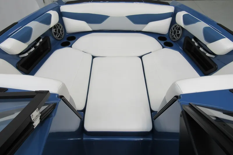 Slide: The Image of 2021 Axis A20 boat interior with blue and white seating, cup holders, and speakers. - 9