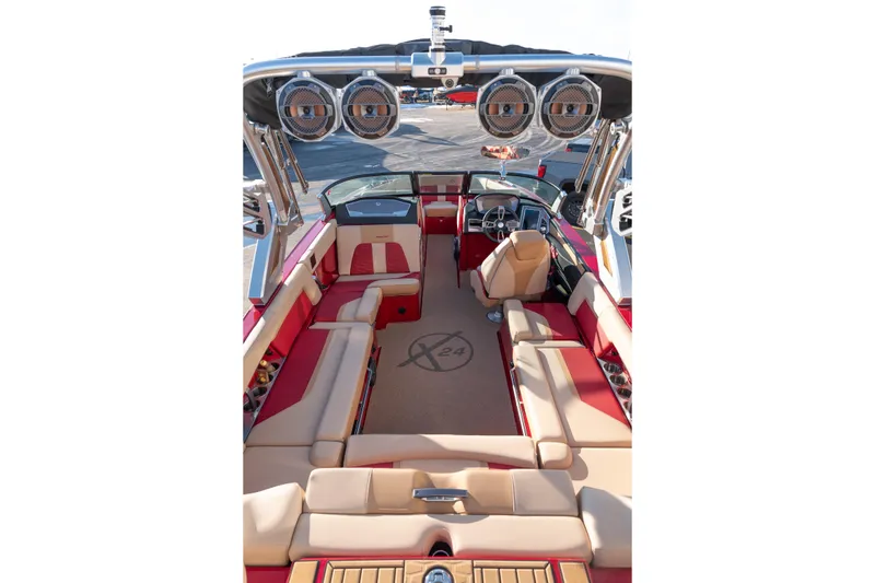 Slide: The Image of 2022 MasterCraft X24 boat interior with red and beige seating, advanced audio system. - 11