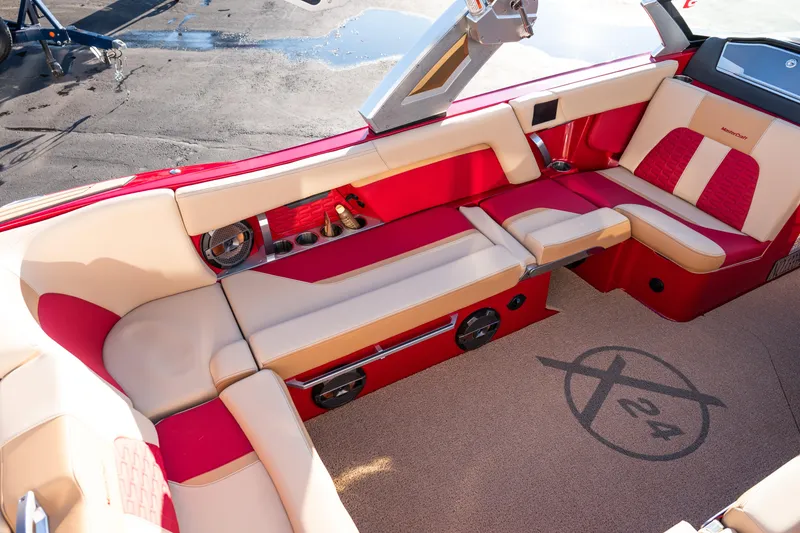 Slide: The Image of 2022 MasterCraft X24 boat interior with red and beige seating, featuring premium audio system. - 13