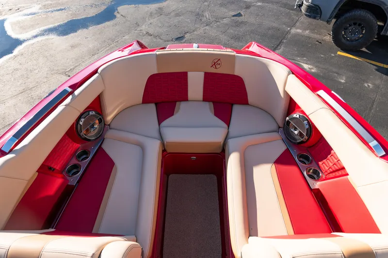 Slide: The Image of Interior of 2022 MasterCraft X24 boat with red and beige seating, cup holders, and speakers. - 19