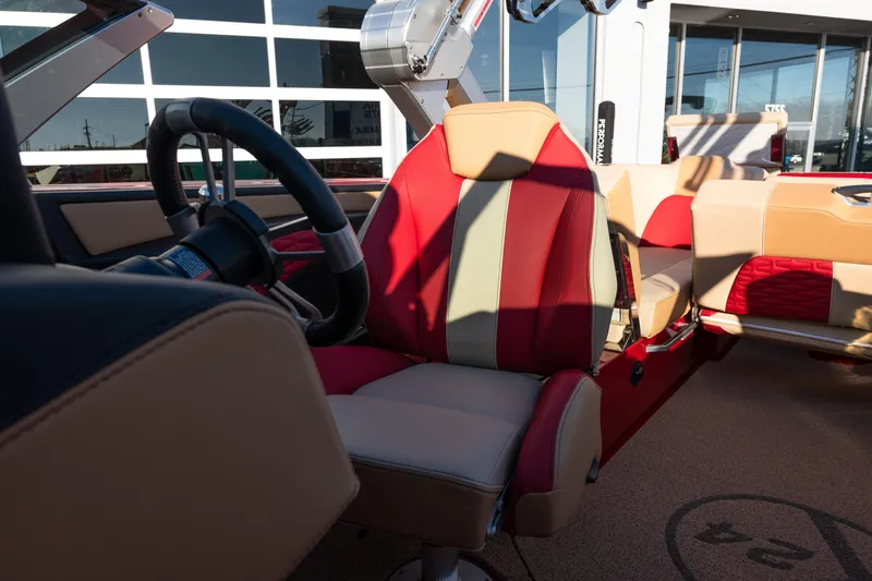 Slide: The Image of 2022 MasterCraft X24 boat interior with red and beige seating, steering wheel visible. - 22