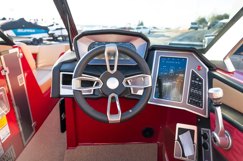 Slide: The Image of 2022 MasterCraft X24 boat dashboard with steering wheel and touchscreen controls. - 23