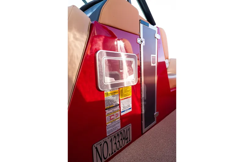 Slide: The Image of Red 2022 MasterCraft X24 boat side view with capacity labels and registration number. - 24