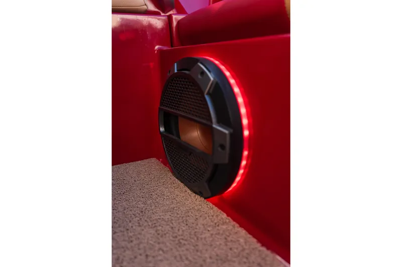 Slide: The Image of 2022 MasterCraft X24 boat interior with illuminated speaker and red upholstery. - 25