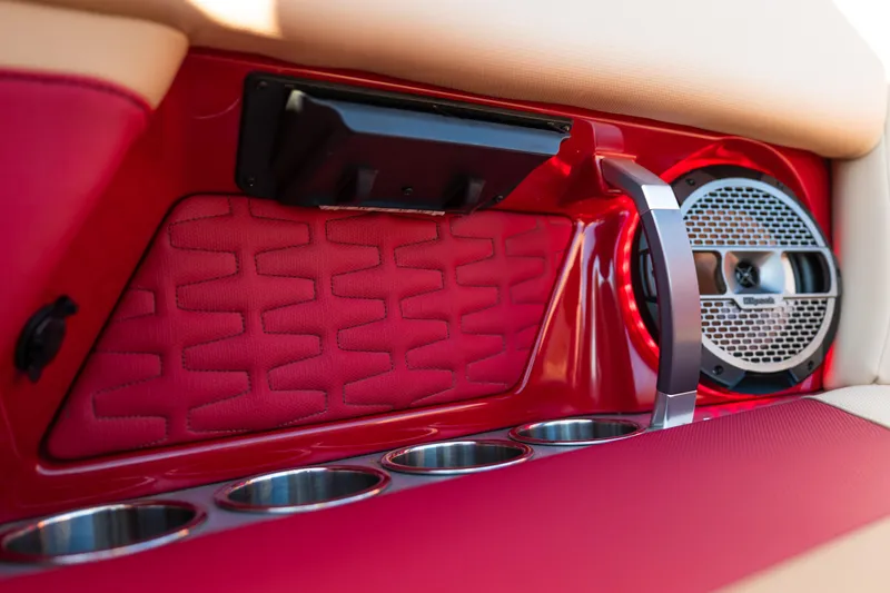 Slide: The Image of 2022 MasterCraft X24 interior with red upholstery, speaker, and cup holders. - 27