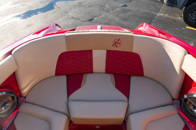 Slide: The Image of 2022 MasterCraft X24 boat interior with red and beige seating, featuring premium audio speakers. - 30