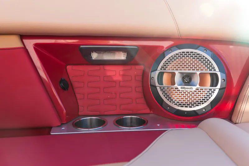 Slide: The Image of 2022 MasterCraft X24 interior with red paneling, speaker, and cup holders. - 31