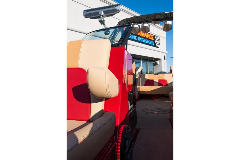 Slide: The Image of 2022 MasterCraft X24 boat interior with red and beige seating, outside a marine sports store. - 33