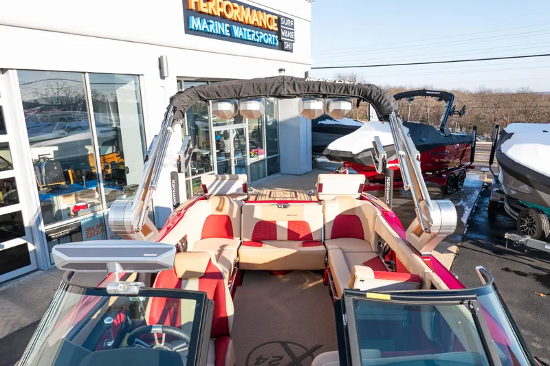 Slide: The Image of 2022 MasterCraft X24 boat with red and beige interior at a marine dealership. - 34