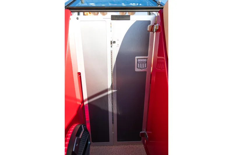 Slide: The Image of 2022 MasterCraft X24 boat interior with sleek metal door and red accents. - 38